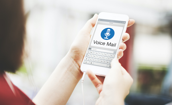 A woman holding a phone displayin a voice mail notification