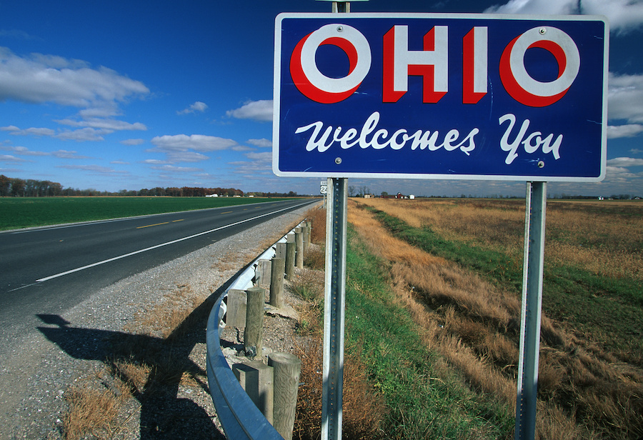 An "OHIO Welcomes You" sign by the side of a highway