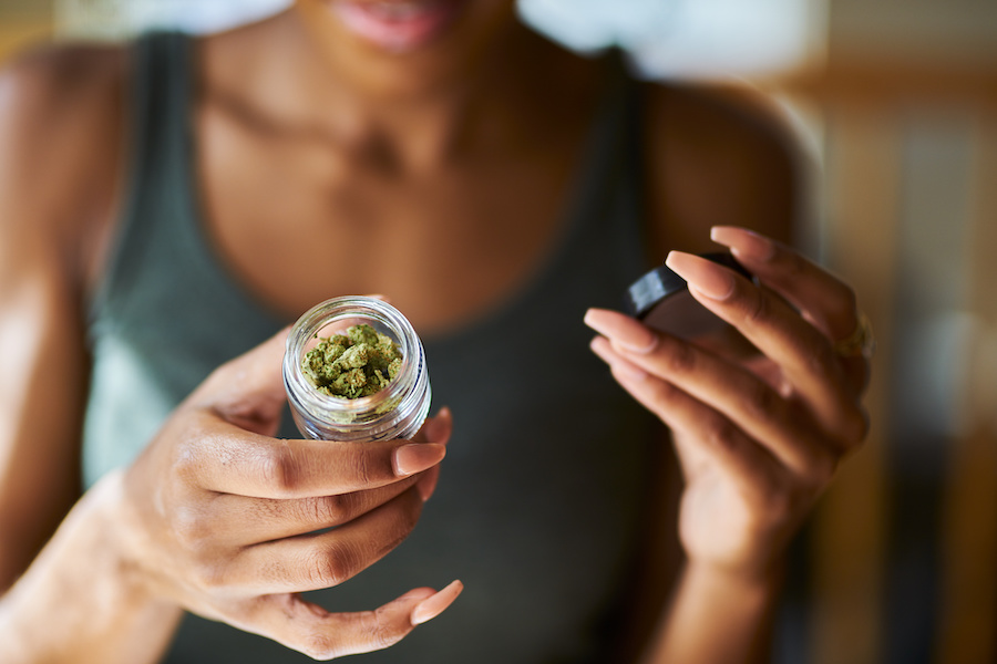 A woman examines a jar of legal marijuana buds