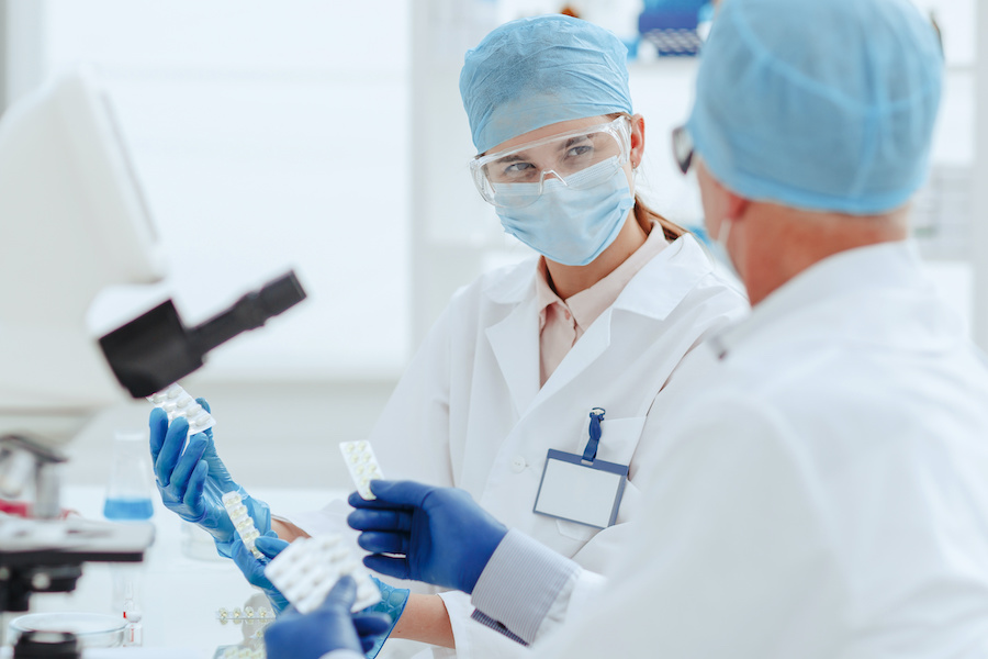 Two laboratory scientists examine pharmaceutical products