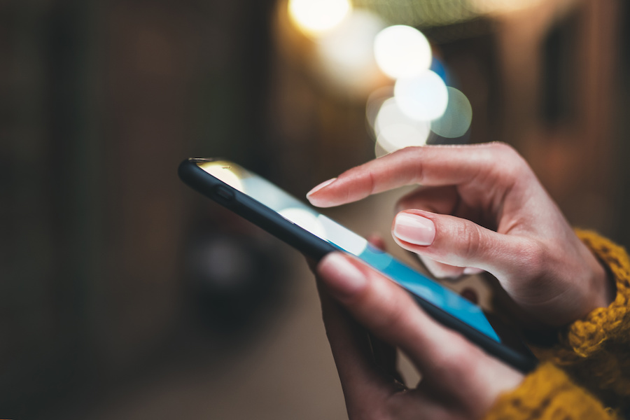 Hands holding a smartphone and typing