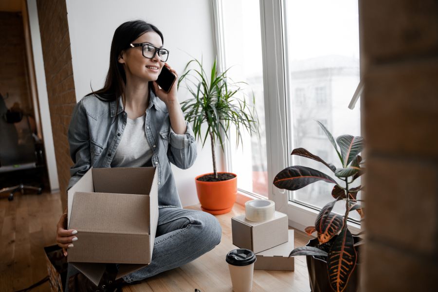 Woman takes an order from a client by phone. Young small business owner, selling online on a website.