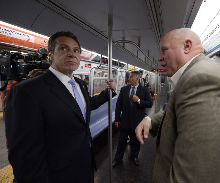 New York Governor Andrew Cuomo unhappily rides the subway with a bald man