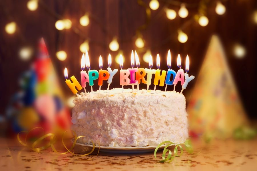 A cake with candles that spell "HAPPY BIRTHDAY"