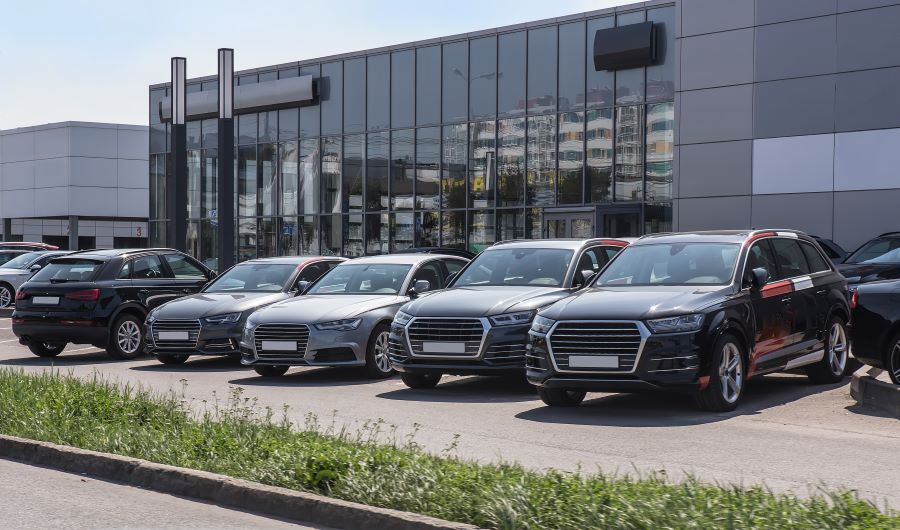 Vehicles for sale, parked in front of an auto dealership