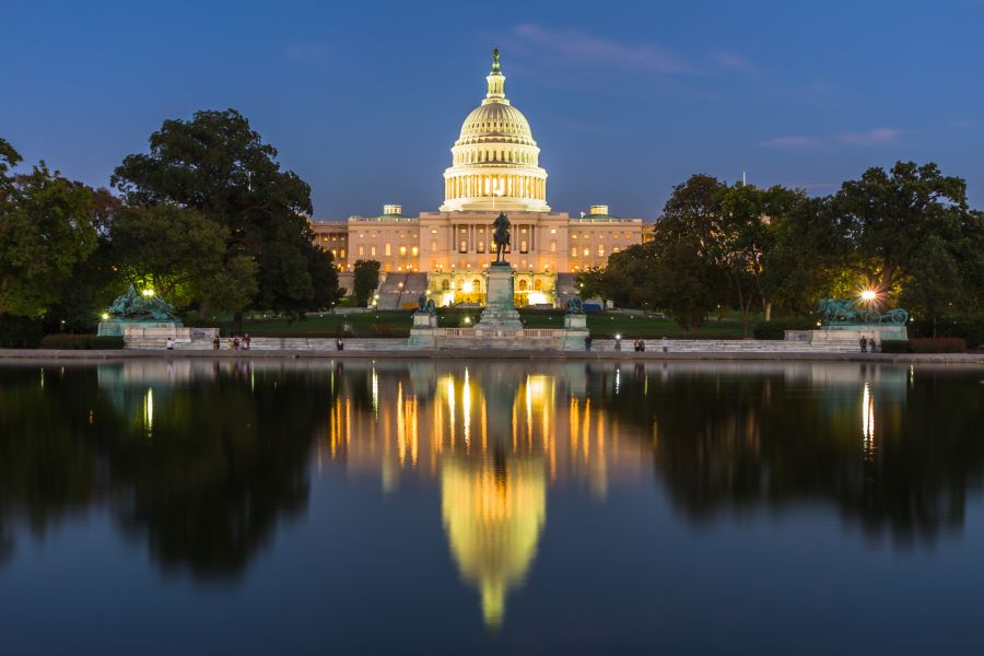 The US Capitol building shown at dusk, with the building's reflection apparent in a reflecting pool