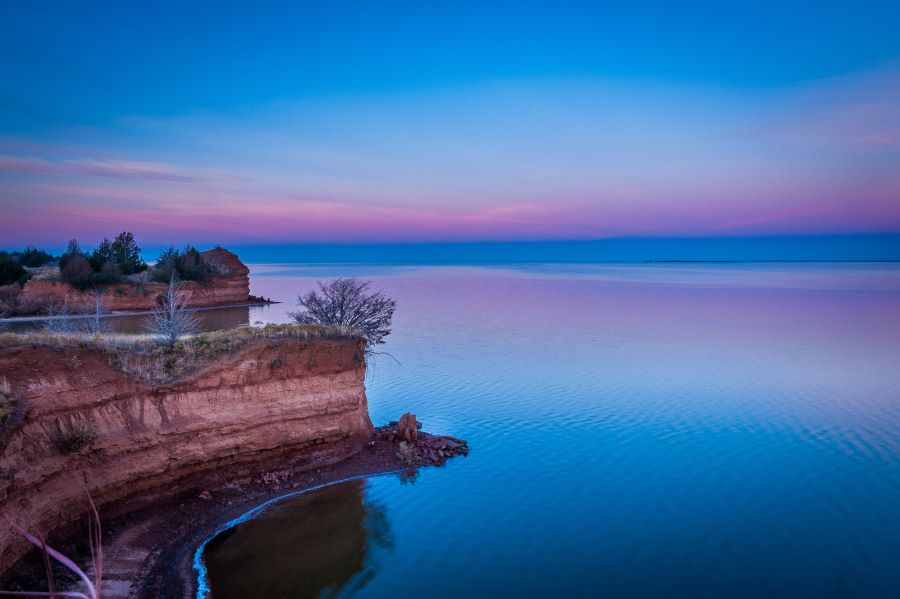 Sunrise over cliffs in front of a lake, Great Salt Plains State Park, Oklahoma