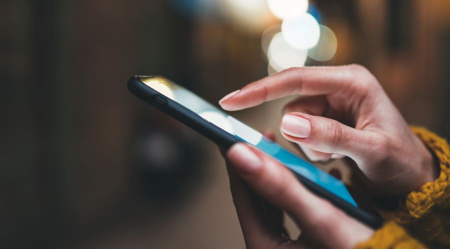 pointer finger on smartphone screen phone closeup, person texting text message